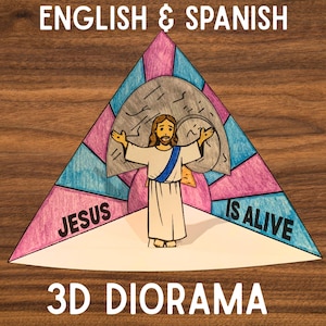 Könnte beinhalten: Ein farbenfrohes 3D-Diorama mit einem dreieckigen Design, das oben den Text "English & Spanish" zeigt. Das Diorama zeigt Jesus mit offenen Armen, den Text "Jesus is Alive" und einen Steinhintergrund.