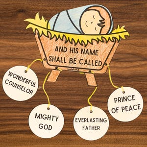 May include: A wooden craft depicting the baby Jesus in a manger with the words "And His Name Shall Be Called" and a verse from Isaiah 9:6.  Four circular tags hang from the manger with the names "Wonderful Counselor", "Mighty God", "Everlasting Father", and "Prince of Peace".