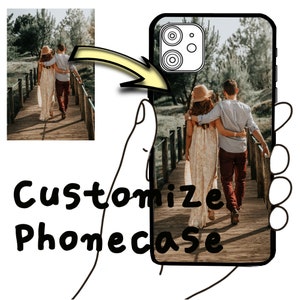 May include: A custom phone case featuring a photograph of a couple walking on a wooden bridge in a woodland setting. The case is black with a transparent back.