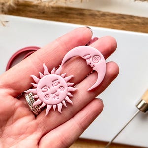 sun and moon polymer clay cut outs with face details.