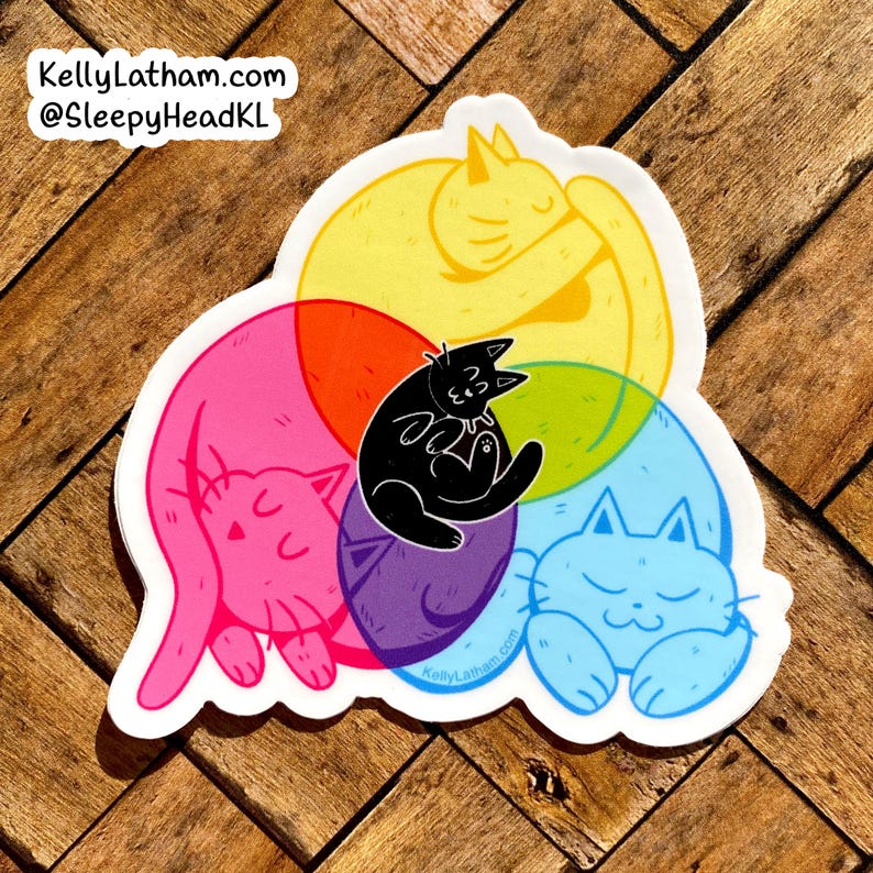 May include: A sticker featuring five cats in a circle, with each cat a different color: yellow, pink, purple, blue, and black. The cats are all curled up sleeping. The sticker has the text "KellyLatham.com" and "@SleepyHeadKL" on it.