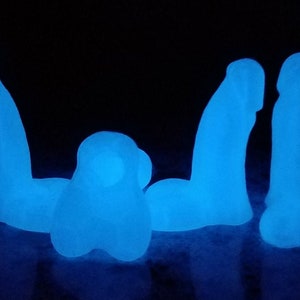 May include: Five glow-in-the-dark blue resin figures. The figures are shaped like a human body.