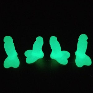 Puede incluir: Cuatro figuritas verdes que brillan en la oscuridad con forma de cuerpo humano.