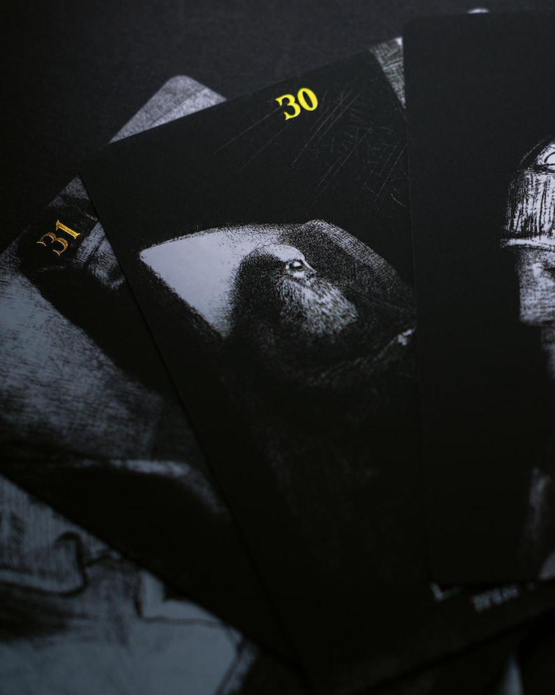 May include: Close-up of several black playing cards with gold numbering. The cards feature a grayscale illustration of a person with a long beard. The number 30 is visible on one card, and the number 31 is visible on another.