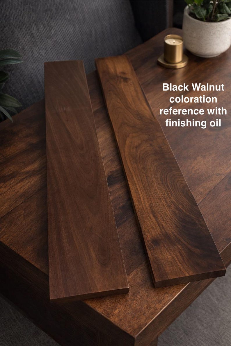 May include: Two rectangular black walnut wood boards with a smooth, oil-finished surface showing natural dark brown grain patterns. The text "Black Walnut coloration reference with finishing oil" is printed on the right side of the image.