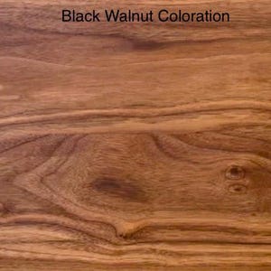 May include: A rectangular piece of wood featuring a rich brown Black Walnut coloration with prominent natural grain patterns, swirling wood knots, and organic dark brown streaks running horizontally across the smooth, polished surface.