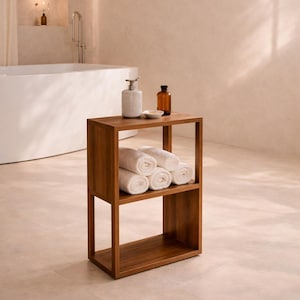 May include: A wooden bathroom shelf unit with two shelves, holding rolled white towels. A soap dispenser and a brown bottle sit on top. The unit is in a bathroom with a bathtub and neutral-toned walls.