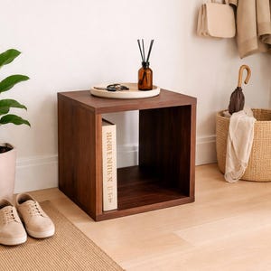 May include: A handmade, wooden serving tray with a natural finish. The tray features a rectangular shape with raised edges and integrated handles. The wood grain is visible, showcasing the tray's rustic charm. Dimensions are approximately 16 inches long, 10 inches wide, and 2 inches high.