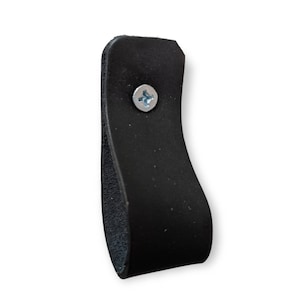 May include: Black leather cabinet pull with a single screw. The pull is shaped like a loop and has a smooth, slightly textured surface.
