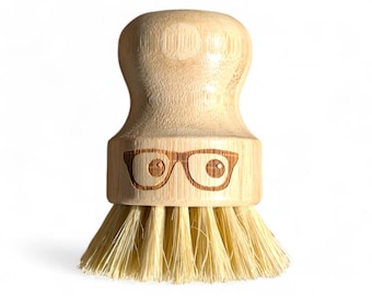 May include: A wooden brush with a natural bristle head and a bamboo handle. The handle has a face with glasses carved into it.