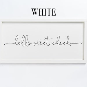 K&ouml;nnte beinhalten: Wei&szlig;e gerahmte Wandkunst mit dem Text "hello sweet cheeks" in schwarzer Kursivschrift.
