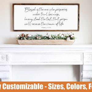 May include: A framed sign with the text "Blessed is the one who perseveres under trial because, having stood the tests, that person will receive the crown of life." The sign is above a white mantel with a wooden trough filled with greenery.