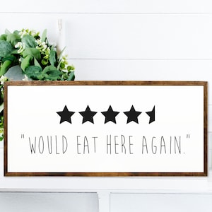 Może przedstawiać: Biały drewniany znak z brązową ramą, z pięcioma czarnymi gwiazdami i tekstem "WOULD EAT HERE AGAIN."