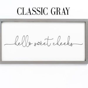 K&ouml;nnte beinhalten: Ein gerahmtes Schild mit dem Text "hello sweet cheeks" in einer kursivschrift. Der Rahmen ist in klassischem Grau.