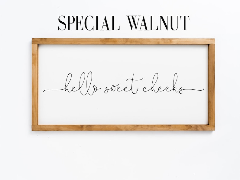 K&ouml;nnte beinhalten: Ein Schild in einem Holzrahmen mit dem Text "hello sweet cheeks" in einer kursivschrift.