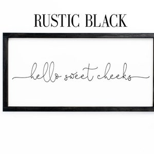 K&ouml;nnte beinhalten: Ein schwarzes gerahmtes Schild mit dem Text "hello sweet cheeks" in einer kursivschrift.