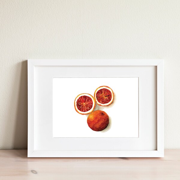 Puede incluir: Una pintura de acuarela enmarcada de tres naranjas sanguinas, dos de las cuales están cortadas por la mitad, revelando su pulpa roja vibrante. Las naranjas están dispuestas sobre un fondo blanco.