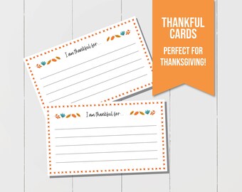 May include: Two blank cards with an orange, teal and brown leaf design and the text "I am thankful for..." printed on each card. The cards have a red and white border.
