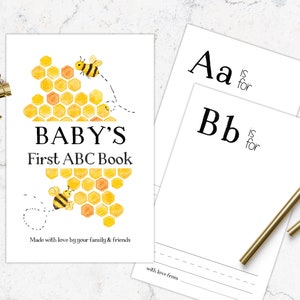 May include: A printable baby's first ABC book with a bee and honeycomb theme. The cover features a yellow and orange honeycomb with two bees flying around it. The text reads "BABY'S First ABC Book" and "Made with love by your family & friends".