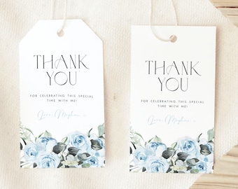 Op de afbeelding: Twee witte cadeaulabels met de tekst "THANK YOU" in het zwart. De labels hebben een bloemenontwerp met blauwe rozen en groen aan de onderkant. De tekst "FOR CELEBRATING THIS SPECIAL TIME WITH ME!" is ook aanwezig.