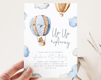 Puede incluir: Un globo aerostático azul y marrón con un osito de peluche en la cesta. El globo está rodeado de nubes blancas con acentos azules. El texto "Up Up & Away" está escrito en cursiva. El texto "Please join us to celebrate Aidan's 1st Birthday" está escrito en azul. El texto "Sunday, 20th November at 2PM" está escrito en negro. El texto "Soft Play Center, 14 Oxford Lane, CA" está escrito en negro. El texto "Kindly RSVP to Josie by November 5th" está escrito en negro. El texto "0412 345 678" está escrito en negro.