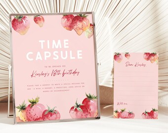 May include: Pink and white time capsule sign with strawberry illustrations. The sign reads "Time Capsule" and "To be opened on Kinsley's 18th birthday".  A smaller pink card with strawberry illustrations reads "Dear Kinsley".
