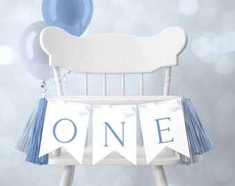 Könnte beinhalten: Ein weißer Hochstuhl mit einem blauen und weißen Banner, auf dem "ONE" steht, mit blauen Quasten an jedem Ende.