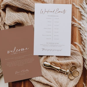 May include: A welcome sign with a brown background and white text that says "welcome friends & family". The sign is next to a white card with a list of weekend events for a wedding. The text on the card includes the time of each event, such as the ceremony, photos, dinner, cake and toast, fireworks, music and dancing, and send off. The card also includes a section for "The Morning After" with information about a wedding brunch.