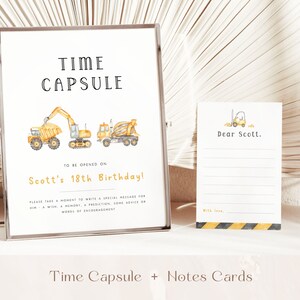 May include: A yellow and black time capsule sign with construction vehicle illustrations. The sign says "Time Capsule" and "To be opened on Scott's 18th Birthday!"  It also includes instructions to write a special message for Scott.  A blank note card with a yellow construction vehicle illustration is also shown.