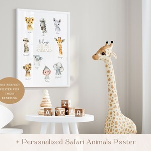 May include: A white framed poster with watercolor illustrations of safari animals, including a giraffe, zebra, cheetah, monkey, and elephant. The poster has the text "Rileys Safari Animals" in gold lettering. A stuffed giraffe toy stands next to the poster.