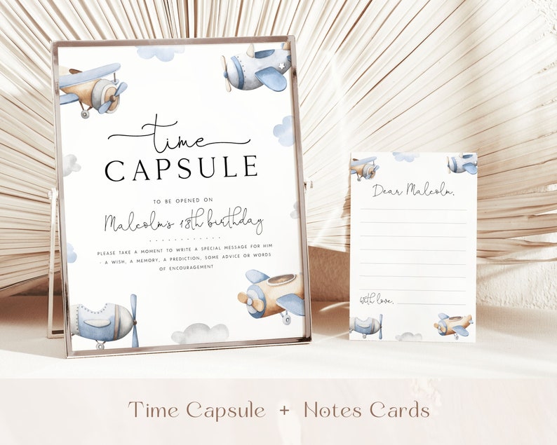 May include: A white sign with blue and brown airplanes and clouds. The sign says "Time Capsule" and "To be opened on Malcolm's 18th birthday".  Please take a moment to write a special message for him - a wish, a memory, a prediction, some advice or words of encouragement.  There are also several blank note cards with blue and brown airplanes and clouds. The note cards say "Dear Malcolm" and "with love".