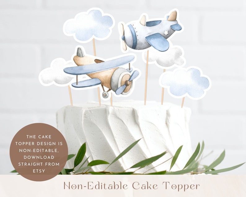 May include: Non-editable cake topper featuring two blue and brown airplanes with white clouds. The cake topper is perfect for a baby shower or birthday party.