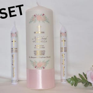 Peut inclure: Ensemble de deux bougies de baptême blanches avec inscription dorée. La plus grande bougie a une base rose et un motif floral. Le texte indique "God Bless Ayla Cheryl Mohella Baptized on 1st of May 2023 Godparents Anthony and Sophia St. Margaret's Anglican Church".