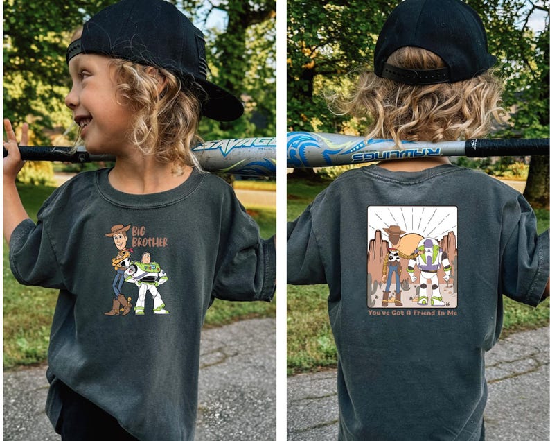 May include: Dark grey t-shirt with a cartoon graphic of Woody and Buzz Lightyear and the text "Big Brother" on the front. The back of the shirt has a matching graphic with the text "You've Got a Friend in Me".