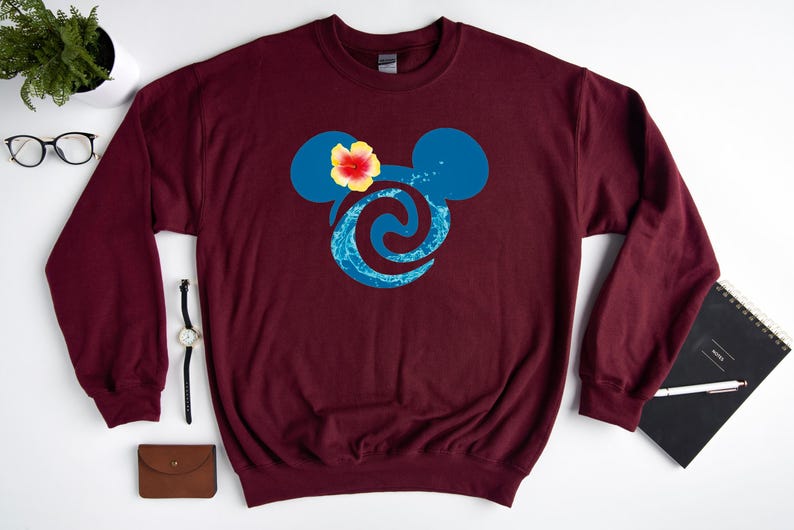 Puede incluir: Sudadera color burdeos con un dise&ntilde;o de cabeza de Mickey Mouse azul y turquesa. La cabeza de Mickey Mouse tiene una flor amarilla en la parte superior.