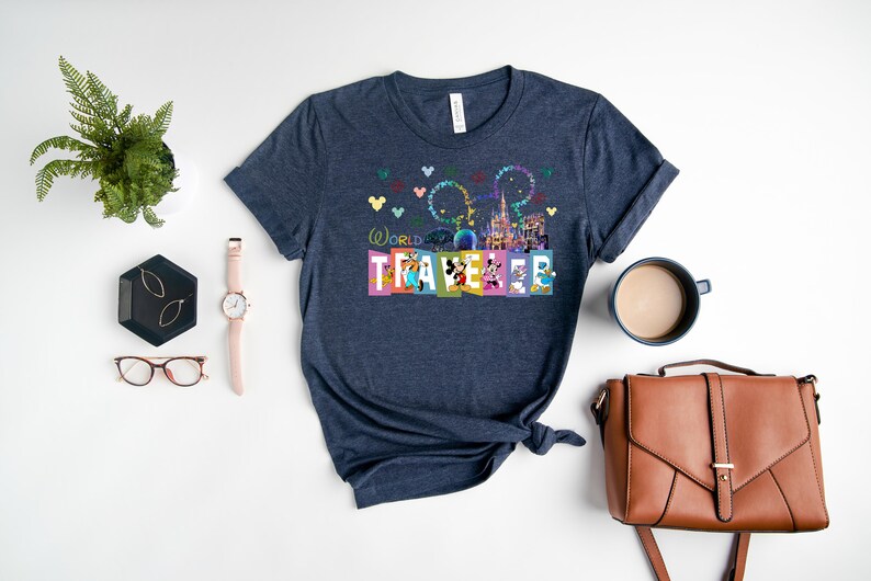 May include: A navy blue t-shirt with a colorful graphic of the Disney World castle, fireworks, and Mickey Mouse characters. The text "World Traveler" is printed on the shirt.