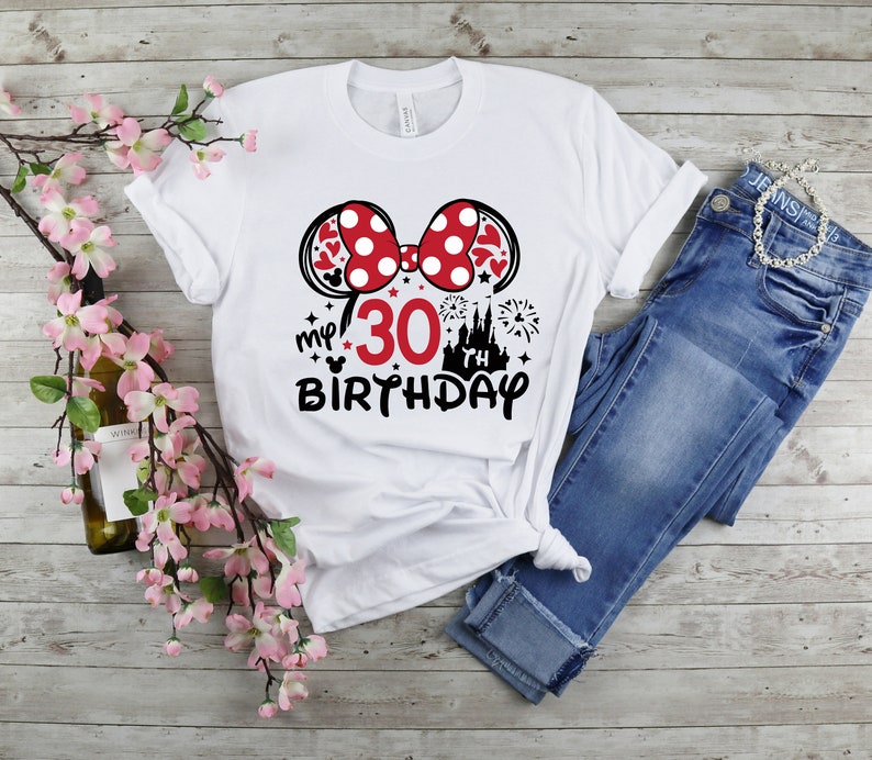 May include: White t-shirt with a black and red Minnie Mouse ears design. The shirt says "my 30 birthday" with a black castle and fireworks graphic.