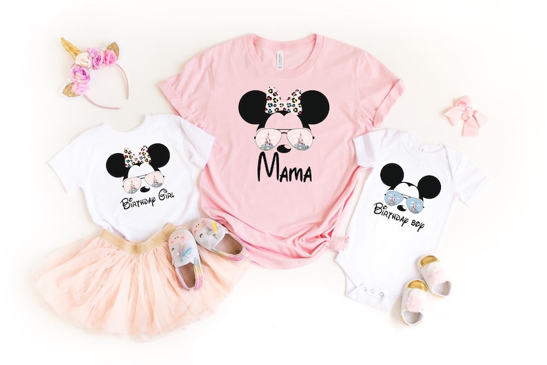 K&ouml;nnte beinhalten: Ein Set aus drei wei&szlig;en T-Shirts mit einer schwarz-wei&szlig;en Comic-Maus, die eine Sonnenbrille tr&auml;gt. Die Shirts sind mit dem Text "Birthday Girl", "Mama" und "Birthday Boy" bedruckt.