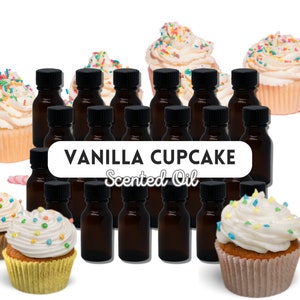 May include: A set of 16 small brown glass bottles with black lids filled with vanilla cupcake scented oil. The bottles are arranged in a grid pattern. The image also includes cupcakes with vanilla frosting and colourful sprinkles.