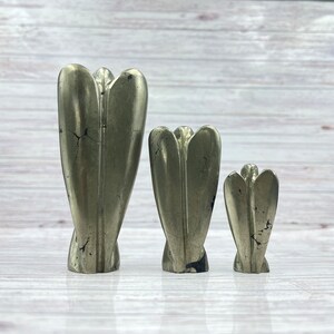 May include: Three gold pyrite angel figurines of varying sizes. The angels are carved from natural pyrite and have a rough, textured surface.