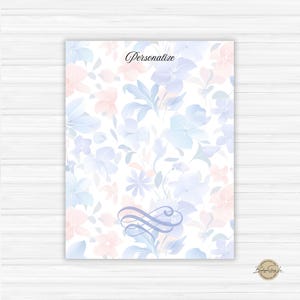 May include: A floral design notepad with a white background and a pattern of blue and pink flowers. The word "Personalize" is written in cursive at the top. A decorative flourish is at the bottom.