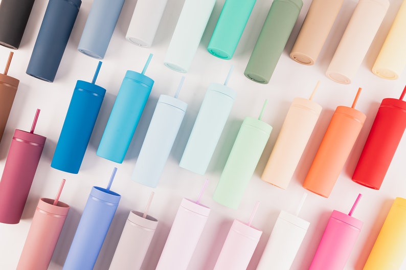 Puede incluir: Una variedad de vasos cil&iacute;ndricos de colores con pajitas. Los vasos son de varios tonos pastel, incluyendo azul, rosa, verde y naranja. Cada vaso tiene una pajita a juego. La imagen est&aacute; tomada desde arriba, mostrando la variedad de colores.