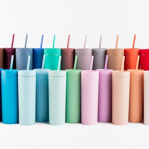 Puede incluir: Una colecci&oacute;n de vasos delgados y coloridos con pajitas a juego. Los vasos est&aacute;n dispuestos en fila, mostrando un espectro de colores que incluyen negro, azul, verde, rosa y amarillo. Cada vaso tiene una tapa y una pajita.