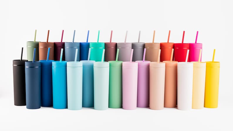 Puede incluir: Una colecci&oacute;n de vasos delgados y coloridos con pajitas a juego. Los vasos est&aacute;n dispuestos en fila, mostrando un espectro de colores que incluyen negro, azul, verde, rosa y amarillo. Cada vaso tiene una tapa y una pajita.