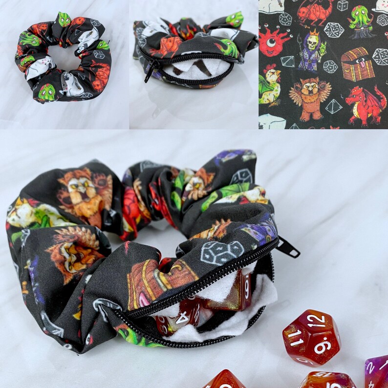 May include: A black scrunchie with a zippered pocket and a white lining. The scrunchie is covered in a repeating pattern of dice, monsters, and other fantasy-themed imagery. The scrunchie is open and filled with red and white dice.