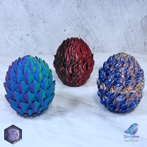 May include: Three dragon eggs, one red with black flames, one blue with gold accents, and one iridescent blue and green. The eggs are made of a textured material and are about the size of a baseball.