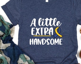 Könnte beinhalten: Ein marineblaues T-Shirt mit dem Text "A little extra handsome" und einem gelben und blauen Band.