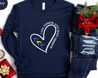 May include: Navy blue long-sleeved shirt with a white heart design and the text "I love someone with Down syndrome".