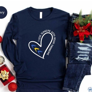 May include: Navy blue long-sleeve shirt with a white heart design and the text "I love someone with Down syndrome".