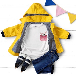 May include: A yellow hooded raincoat with navy trim, a white t-shirt with a pocket design featuring a fox, blue jeans, and navy shoes with white spots. A colourful banner is in the background.